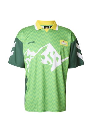 Maglietta verde a maniche corte con colletto giallo, caratterizzata da una grafica bianca di una montagna e un motivo a spina di pesce; include strisce nere e bianche sulle maniche.