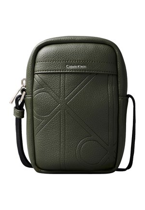 Geantă crossbody mică Calvin Klein verde măsliniu cu inițiale mari în relief și curea neagră reglabilă, închidere cu fermoar pe partea stângă.