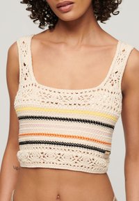 Gehaakt crop top met een beige kleur, open kantontwerp bij de halslijn, en multicolore horizontale strepen in geel, zwart en oranje.