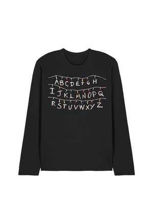 Black long-sleeve shirt with alphabet letters arranged in three rows, above and below strands of multicolored Christmas lights.