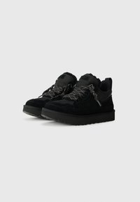 Zwarte sneakers met een bovenwerk van suede en stof, gestructureerde veters, een gewatteerde tong en een dikke rubberen zool met een profiel.
