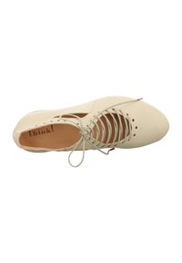 Light beige lace-up shoe with a smooth leather texture, pointed toe, cut-out design on the sides, and a small red accent on the heel.