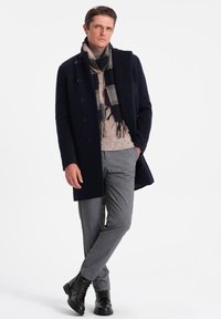 Merino villakangastakki, harmaat ruudulliset housut, beige neulepusero, musta raidallinen huivi, mustat nahkaiset nauhakenkä. Yksinkertainen, muokattu muotoilu.