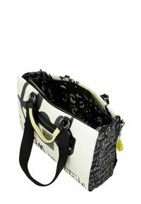 Texturierte Handtasche in Weiß und Schwarz mit Schriftmustern. Verfügt über einen eleganten Metallgriff, Reißverschluss und ein farbenfrohes Innenfutter.
