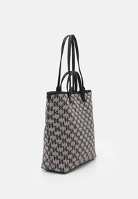 Large tote bag made of woven fabric in gray with a geometric black pattern. Features black leather accents and double shoulder straps.