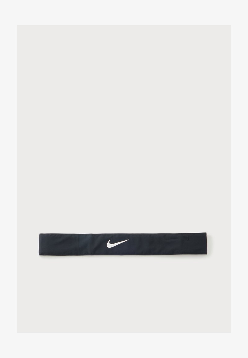 Черна лента за глава на Nike с бяло лого Nike swoosh, центрирано върху обикновен светлосив фон.