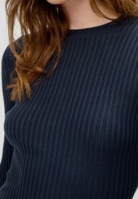 Marineblauer Ripppullover mit Rundhalsausschnitt und langen Ärmeln, aus weichem Strickstoff mit strukturiertem Muster.