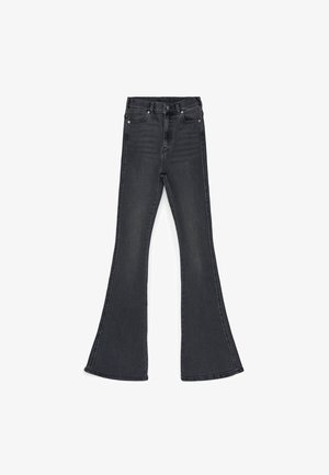 Black flared jeans made of denim. Features a high waist, five pockets, and metal hardware. The hem flares out significantly at the bottom.