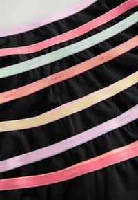 Sedem čiernych textilných pásov na pás s elastickými pásmi v pastelových farbách ružovej, oranžovej, žltej a zelenej, každý s vyrazeným nápisom "NEXT".