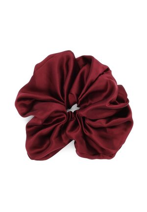 Stor bordeaux rød satin scrunchie med en opsamlet, skinnende stoftekstur arrangeret i bløde folder på en hvid baggrund.