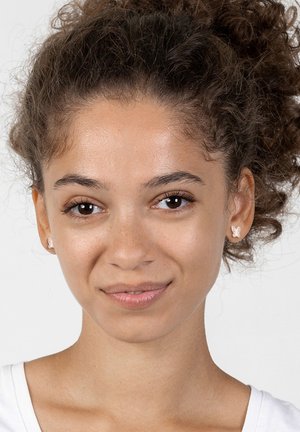 Ohrringe in Form von Schmetterlingen in sanften Pastellfarben, mit zarten Details und einer glatten Oberfläche. Das Modell hat lockiges Haar.