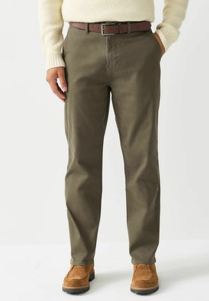 Olivengrønne bukser lavet af blød bomuld, med en lige ben-design, sidelommer og et brunt læderbælte med en sølvspænde.