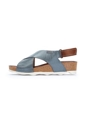 Sandalia de satén azul con tira cruzada, plantilla de corcho, acento en cuero marrón, suela blanca y correa trasera ajustable. Diseño casual con materiales texturizados.