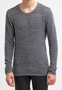 Suéter de manga larga con cuello redondo en un tejido gris texturizado. Presenta un ajuste slim y una tela suave, con un dobladillo ligeramente alargado en la cintura.