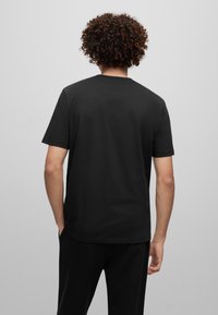 Sort bomulds t-shirt med korte ærmer, rund hals og en afslappet pasform. Har en glat tekstur og et enkelt, udekoreret design.