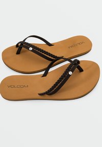 Infradito marroni con cinturini intrecciati neri. Soletta liscia color tan con logo nero. Design elegante adatto per un abbigliamento casual.