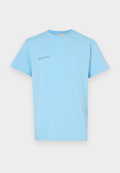 Lyseblå bomulds T-shirt med korte ærmer, rund halsudskæring og en lille, mørk tekstdetalje på øverste venstre side.