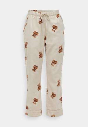 Cotton lounge pants in beige with a printed teddy bear pattern. Features an elastic waistband with a drawstring and cuffed hems.