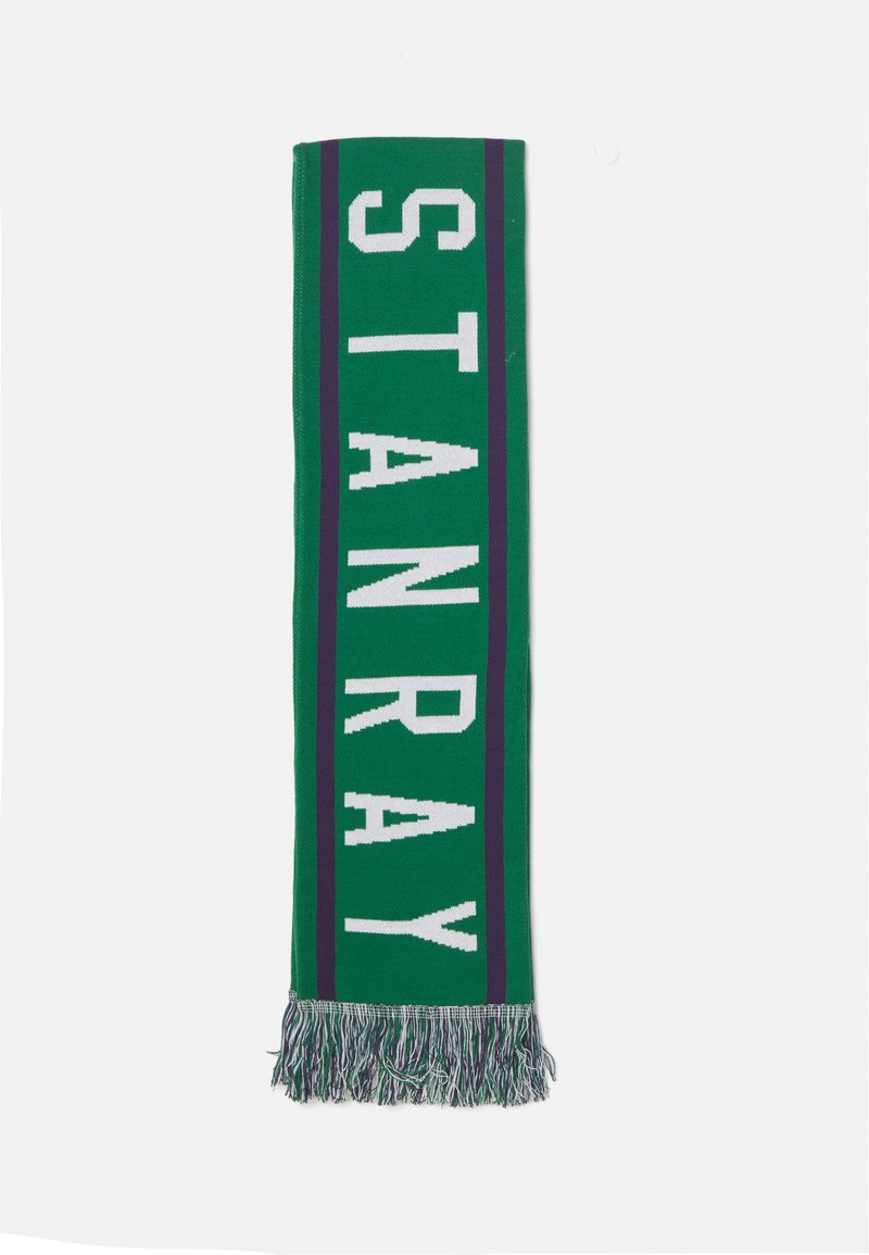 Cachecol verde tricotado com letras em bloco brancas a soletrar "STANRAY", com riscas roxas e detalhes em franjas numa das extremidades.