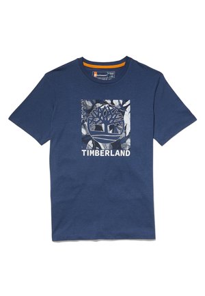 Tmavě modré tričko s krátkým rukávem s velkým čtvercovým logem stromu Timberland a bílým nápisem na přední straně.