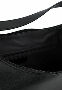 Zwarte leren handtas met een gladde textuur, bovenste ritsluiting en een enkele schouderband. Het interieur heeft een klein ritsvak.