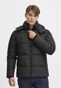 Sort puffjakke med hætte, i et quiltet design, med frontlynlås og sidelommer. Stoffet ser glat og isoleret ud.