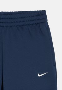 Tamno plave sportske kratke hlače s elastičnom gumicom u struku i bočnim džepovima. Na prednjoj strani nalazi se mali bijeli Nike logo. Glatka tekstura.
