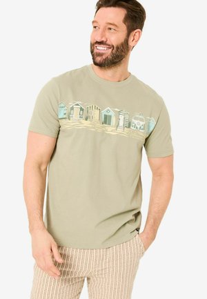 Light green cotton t-shirt featuring a beach hut graphic in various colors. Short sleeves, crew neck, and a relaxed fit.