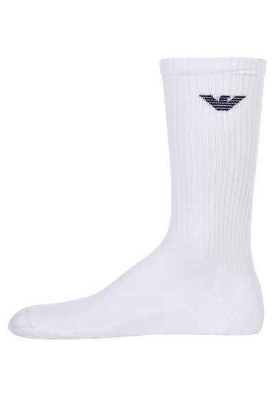 Calzino bianco in miscela di cotone, con texture a coste. Include un piccolo logo nero sul lato superiore. Design classico, fino al ginocchio.