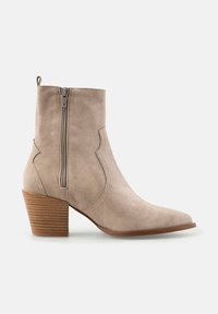 Botină bej din suede, cu vârf ascuțit, fermoar lateral și toc din lemn stratificat. Prezintă cusături accentuate curbe pe laterale.