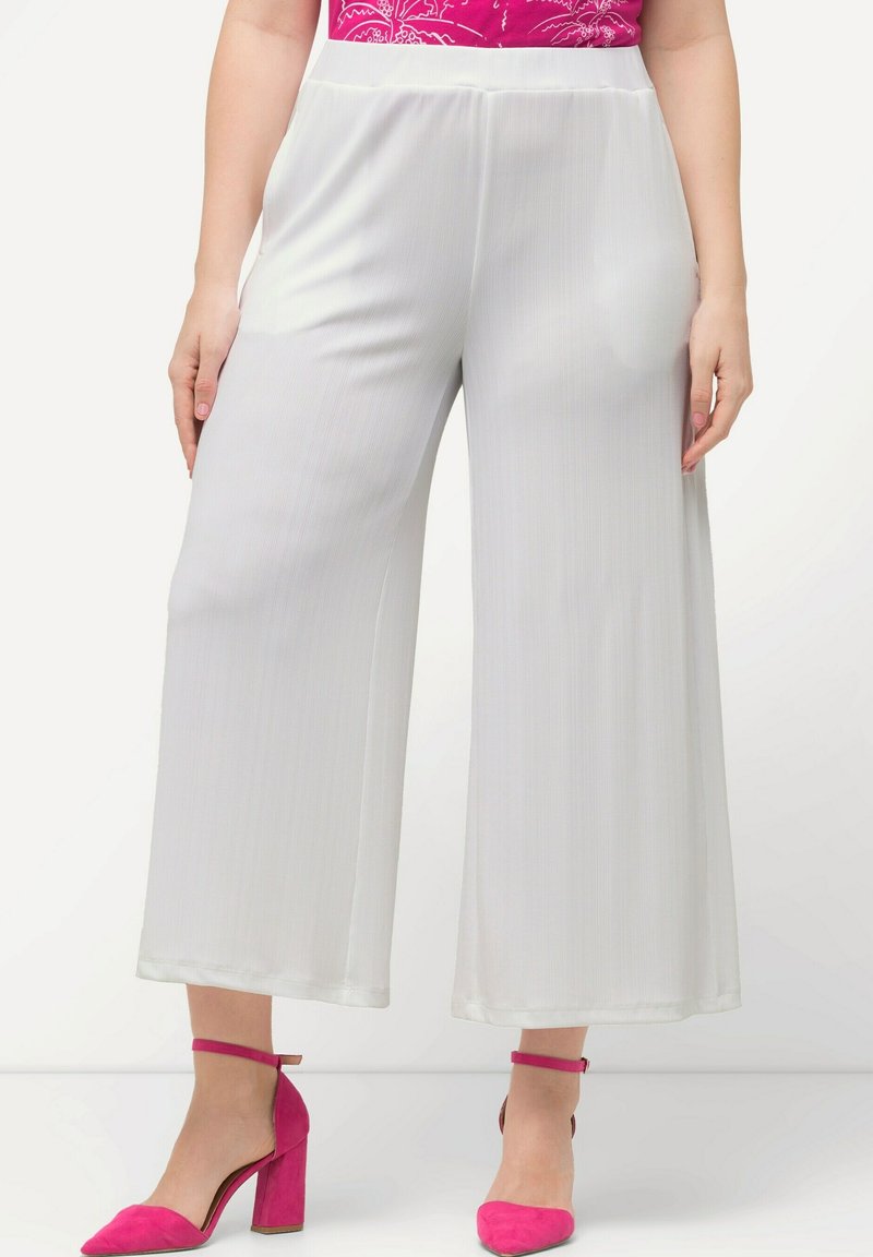 Weiße, weit geschnittene Hosen aus glattem Stoff. Mit hoher Taille und subtiler vertikaler Textur, kombiniert mit hellrosa High Heels.