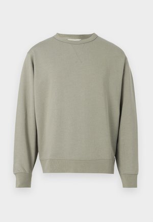 Zelts džemperis ar apaļu kakla izgriezumu, garām piedurknēm un ribotām aprocēm. Mīksta, teksturēta auduma, ar nedaudz brīvāku piegriezumu.