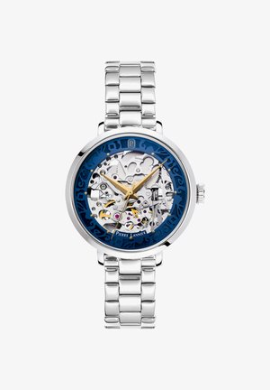 Sidabrinės spalvos metalinis apyrankės laikrodis su matomais vidiniais mechanizmais, mėlynas išorinis žiedas, auksinės valandų ir minučių rodyklės bei sekundžių rodyklė rodanti 3:24:51.