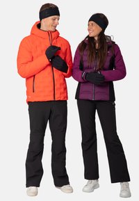 Two individuals wearing outdoor gear: one in an orange padded jacket, black gloves, and black pants; the other in a purple insulated jacket and black pants.