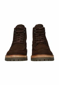 Rudos suede tipo aulinukai iki kulkšnies su raištelių uždarymu, apvaliais pirštais ir tekstūruotais guminiais padais, turinčiais sluoksniuoto medžio efektą apačioje.