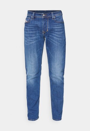 Sinine denimist teksapüksid sirge lõikega, millel on pleekinud viimistlus, viis taskut ja kontrastõmblused õmbluste ääres.