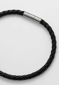 Bracciale in pelle intrecciata nera con chiusura metallica, caratterizzato da una superficie liscia e forma cilindrica.