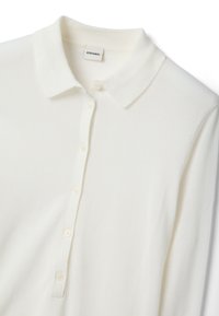 Weißes langärmliges Poloshirt aus leichtem Stoff, mit Kragen, Knopfleiste und gerippten Details am Kragen und der Knopfleiste.