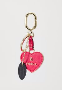 Furla ključna oznaka u obliku srca od živopisne crvene kože s zlatnim hardverom, s dekorativnim crnim listnim visećim detaljem i zlatnim lancem.