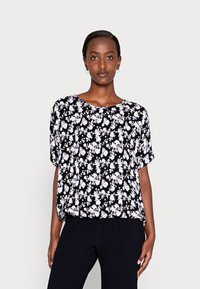 Blusa preta de flores com mangas curtas, apresentando flores brancas e lavanda, corte solto, decote redondo e textura de tecido macio.