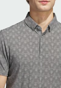 Gray polo shirt with a textured striped pattern in black and white, featuring a collared neckline and two button closure.