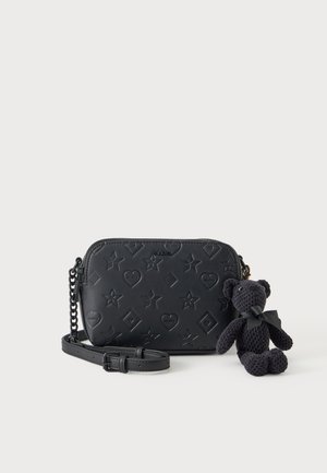 Čierna crossbody taška s reliéfnym vzorom hviezd, sŕdc a diamantov, pripojený čierny retiazkový popruh a malý čierny pletený medvedík s mašľou.