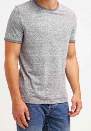 T-shirt gris à manches courtes avec une finition texturée, contrasté par un col côtelé gris foncé. Associé à un jean bleu.