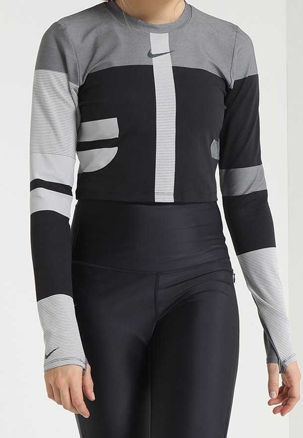 Schwarz und grau gestreiftes Sportoberteil mit langen Ärmeln und einem cropped Design. Es hat gestreifte Muster und eine figurbetonte Silhouette, gefertigt aus dehnbarem Stoff.