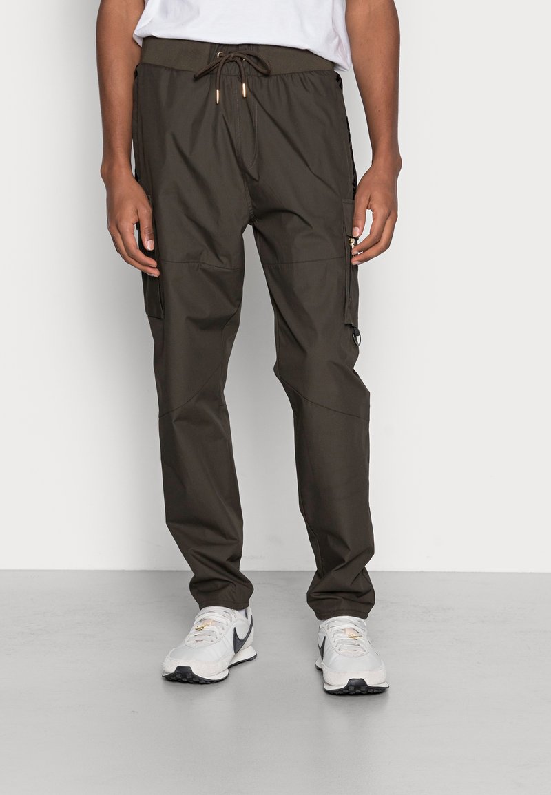Leichte Cargo-Hose in dunklem Olivgrün, mit elastischem Bund und Kordelzug, mehreren Taschen und einer glatten, matten Oberfläche.