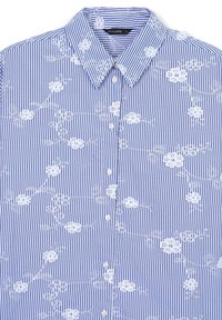 Camicia a righe blu con ricami floreali bianchi, dotata di colletto a camicia, bottoni frontali e una trama di tessuto liscia.