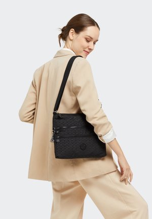 Black fabric crossbody bag featuring three zippered compartments and a logo accent. The strap is adjustable for comfort.