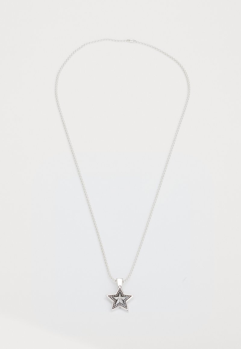 Sudraba kaklarota ar zvaigznes piekariņu, kas ietver slāņotu zvaigznes dizainu ar maziem akcentiem. Ķēdīte ir plāna un ar spīdīgu apdari.