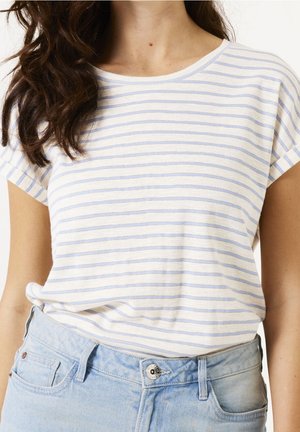 Woman wearing a white T-shirt with thin blue horizontal stripes and light blue high-waisted denim jeans.