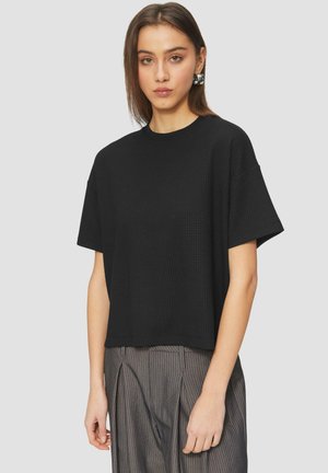 Zwart T-shirt met korte mouwen van textuurstof, ronde halslijn en een ontspannen pasvorm, in combinatie met gestreepte broek.